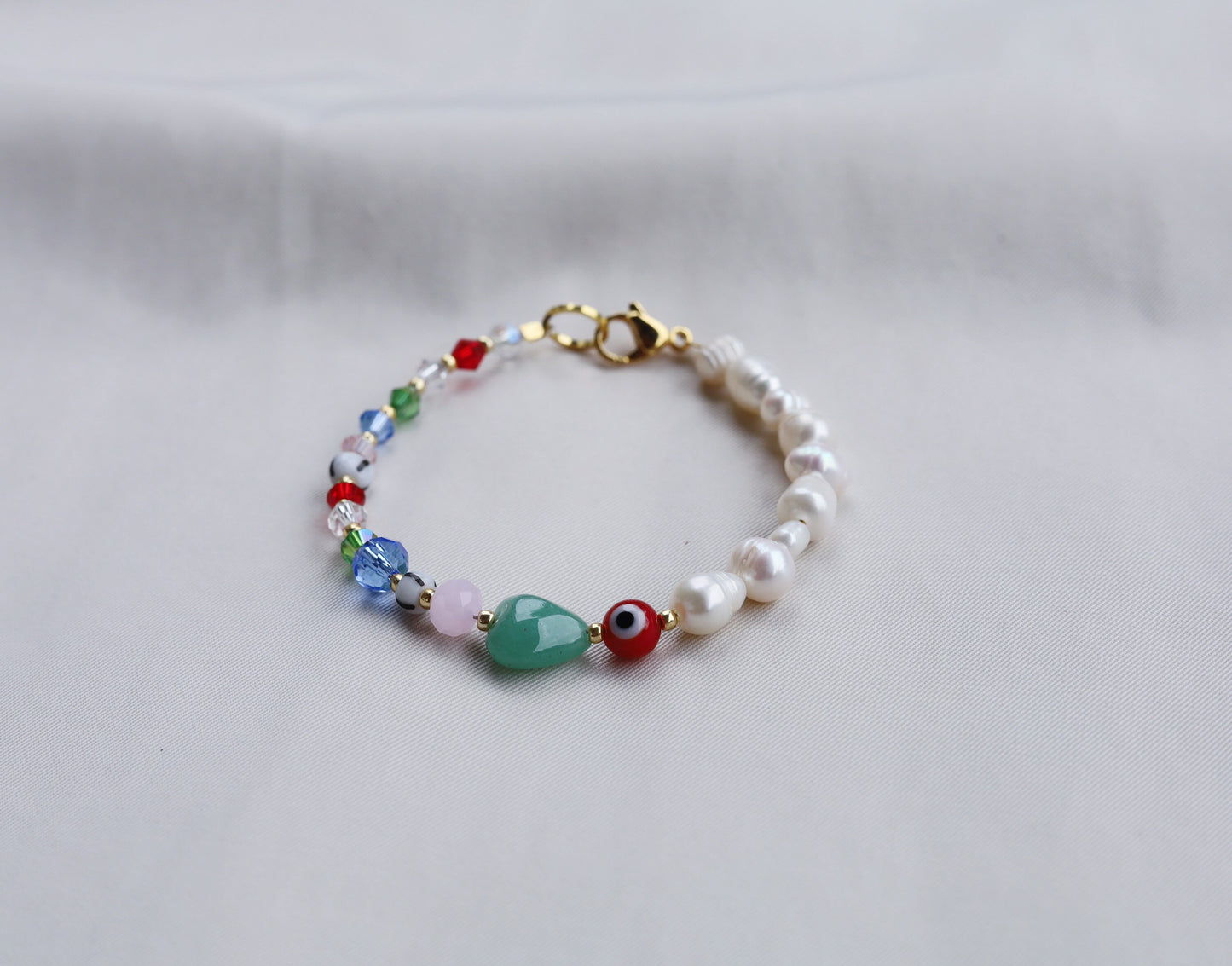 Pearl bracelet with evil eye and heart beads